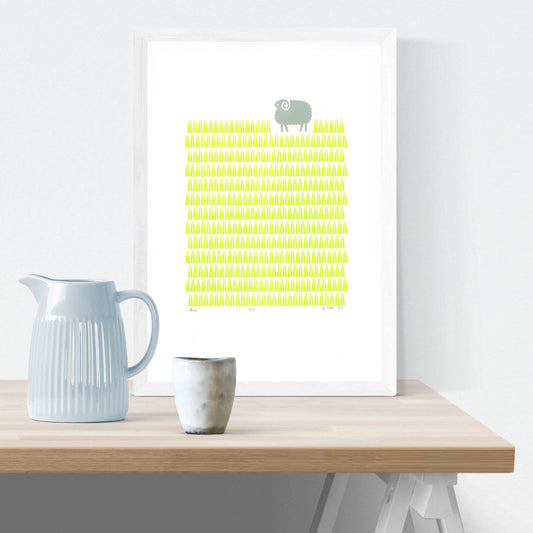 Scandinavian style graphic landscape print of a little sheep in a bright green grass meadow. A modern and playful addition to a well-designed baby nursery.